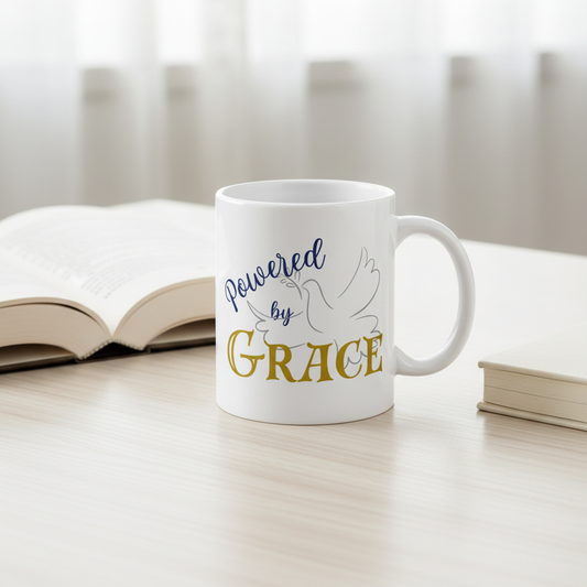 Powered by Grace mug with book and journal on light wood table